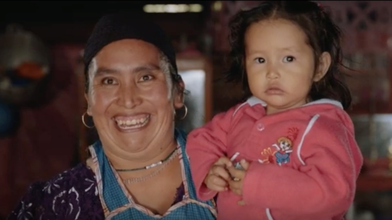 NRECA International Program: mother holding daughter smiling as lights come on